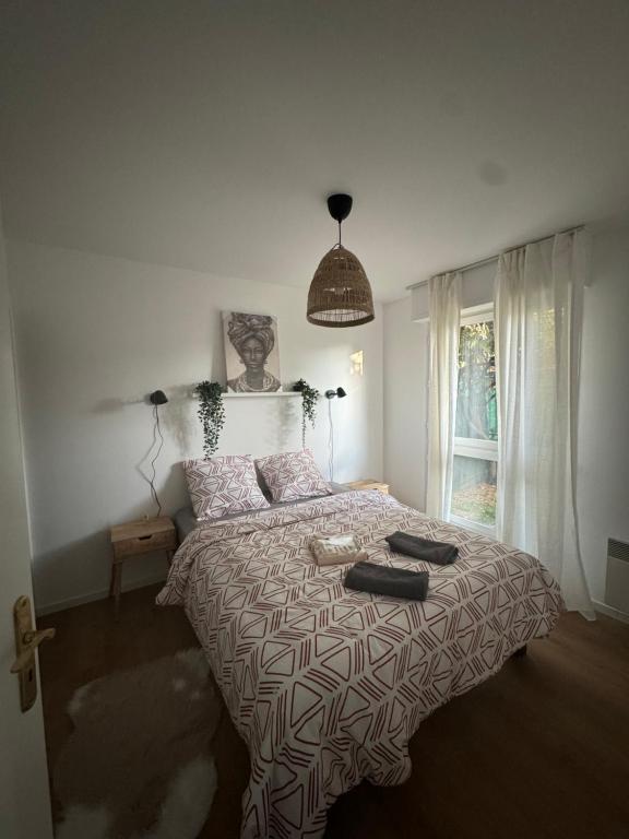 une chambre avec un lit avec une couette et une fenêtre dans l'établissement La Fleur de Montmagny, à Montmagny