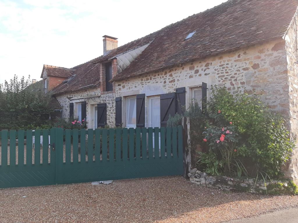 une clôture verte devant une maison dans l'établissement petit gite l'ecotay, à Tennie