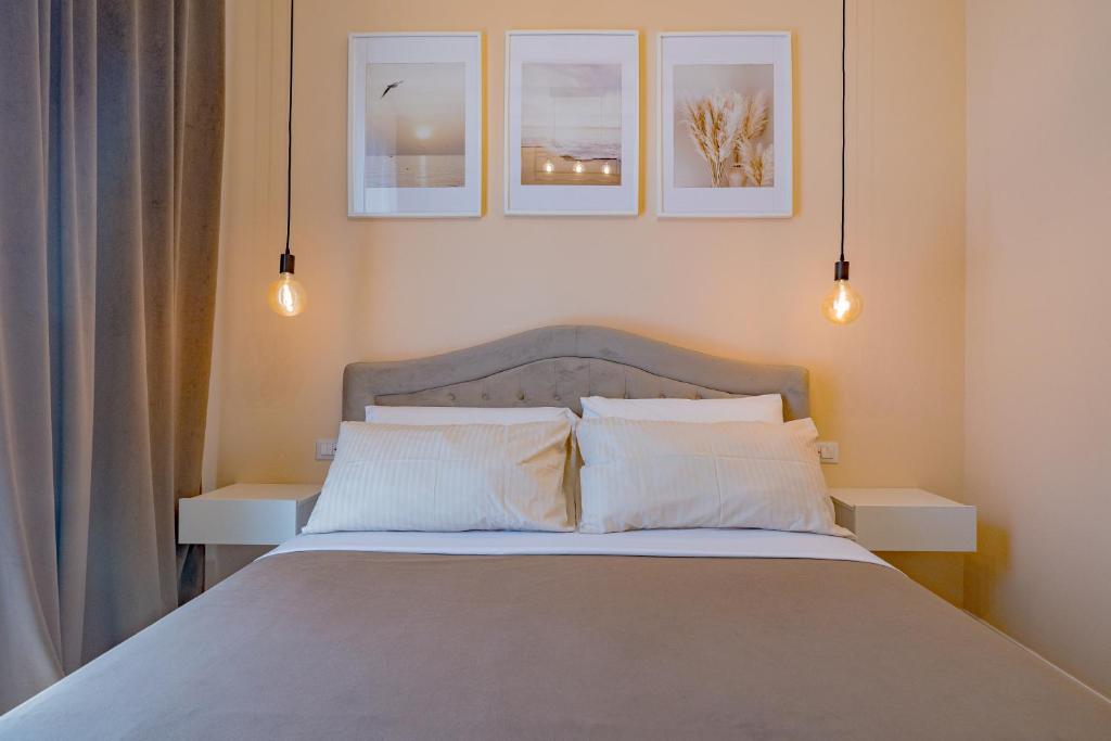 a bedroom with a bed with three pictures on the wall at Visconti Room by Rhospitality it in Rho