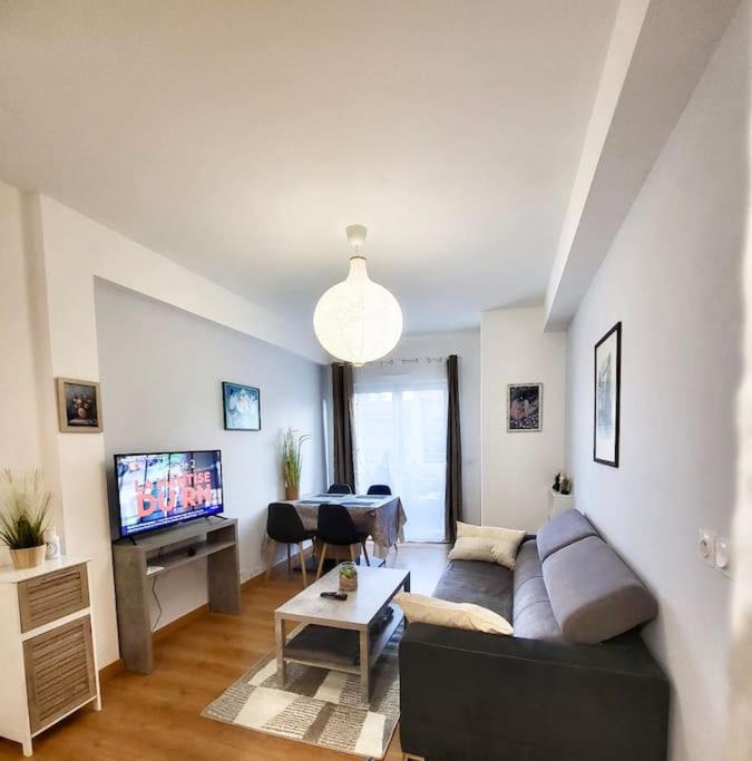 un salon avec un canapé et une télévision dans l'établissement Résidence Les Oliviers de Juin, à Vence