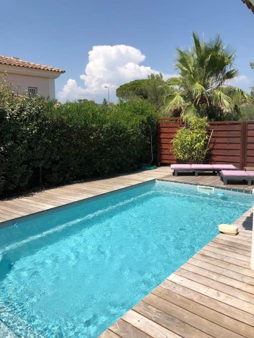 - une piscine dans une cour avec une terrasse en bois dans l'établissement Villa avec piscine SAINT-RAPHAEL, à Valescure