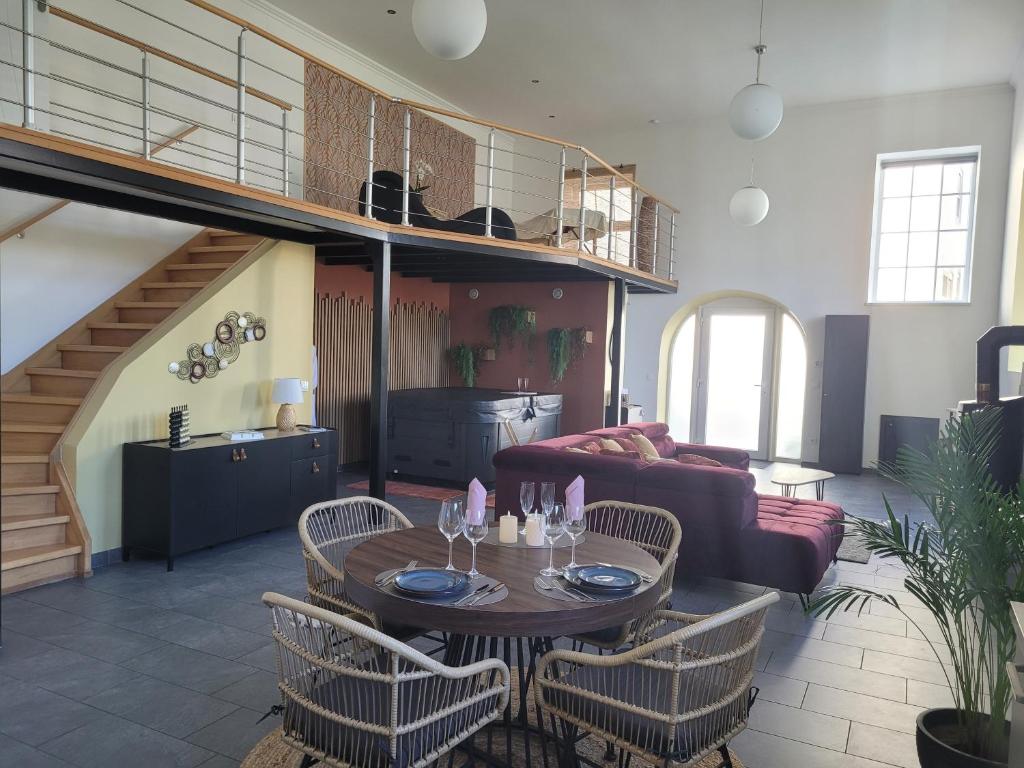 un salon avec une table, des chaises et un canapé dans l'établissement L'instant des Plaisirs, à Héming