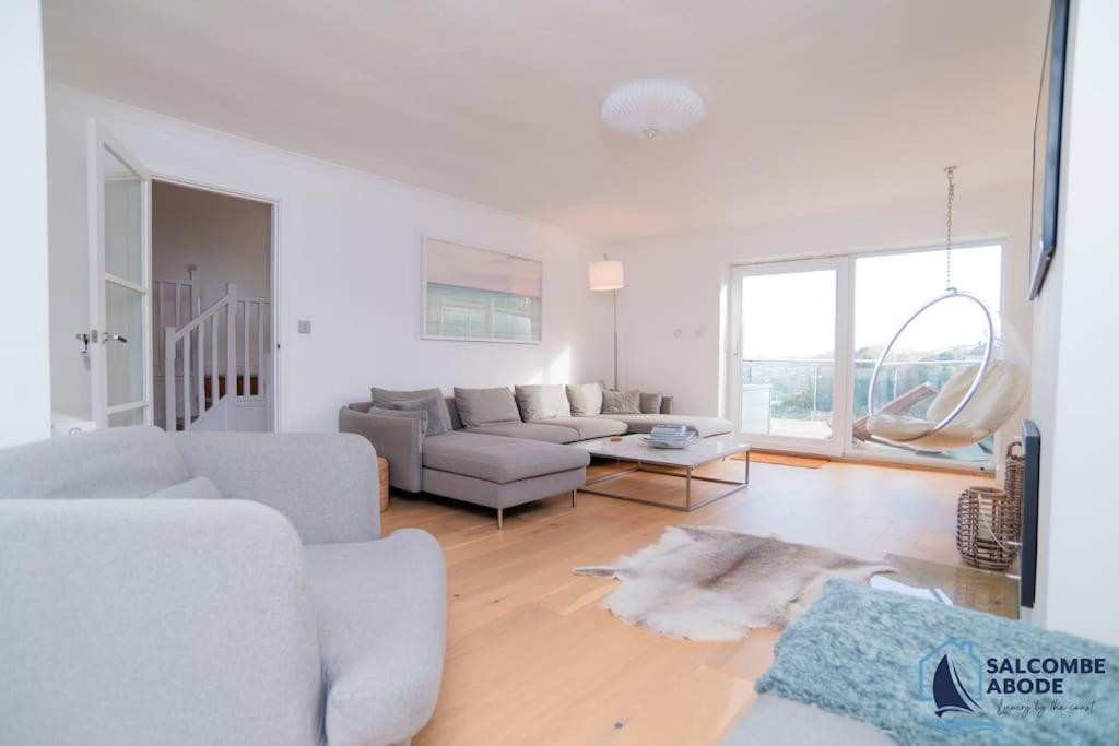 a white living room with a couch and a table at Ultimate Coastal Escape - Stylish & Estuary Views in Salcombe