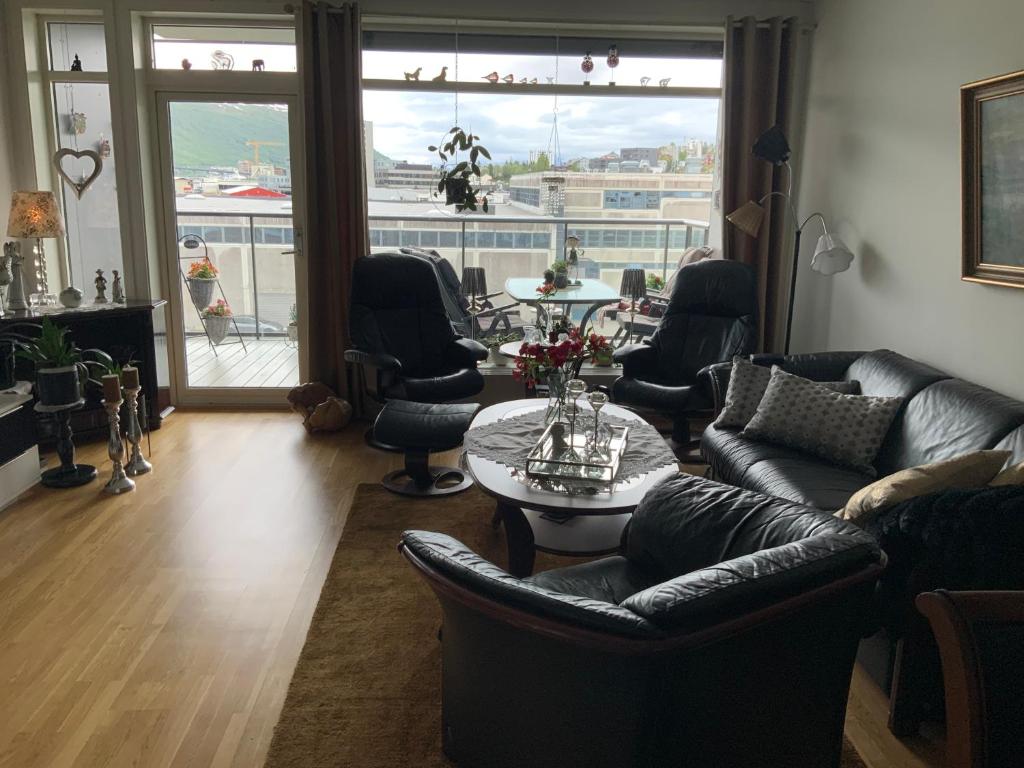 a living room with a couch and chairs and a table at Sentrums nær leilighet in Guleng