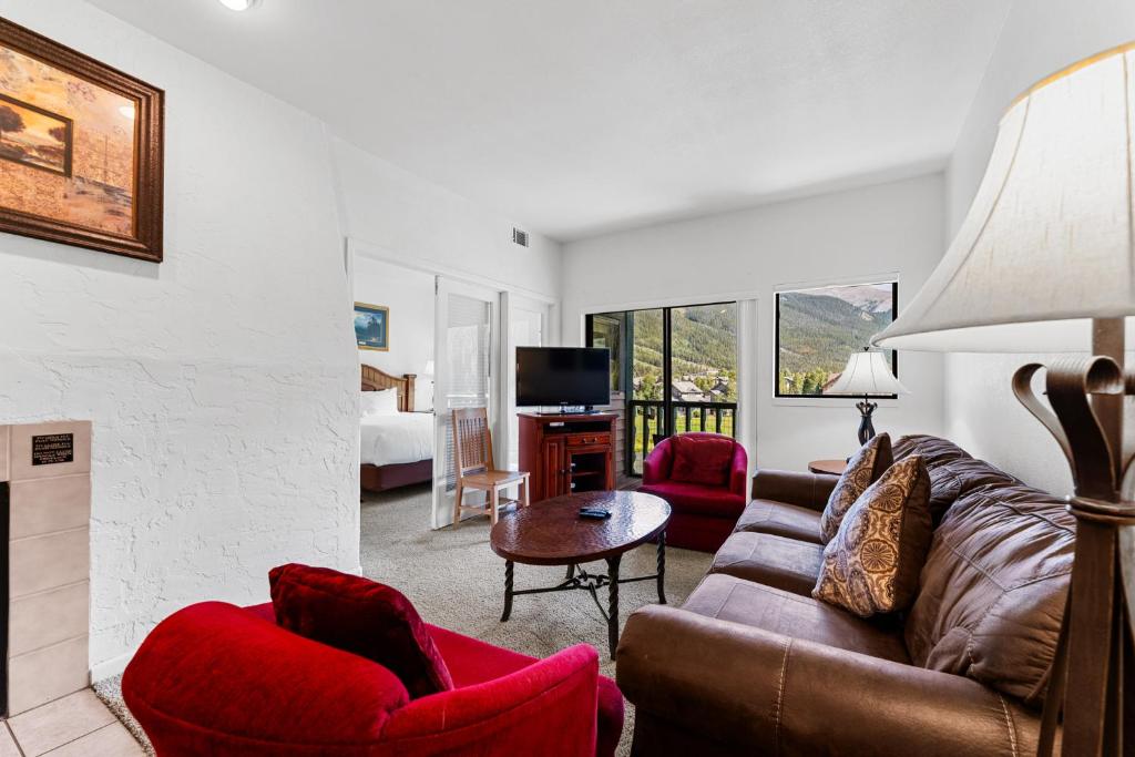 Una sala de estar con un sofá y sillas y un televisor. en Greens at Copper 317 by Summit County Mountain Retreats, en Copper Mountain