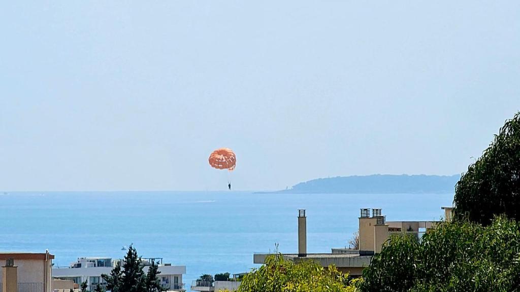 un ballon à air chaud dans le ciel au-dessus de l'eau dans l'établissement Studio lumineux avec parking privé, à Cagnes-sur-Mer