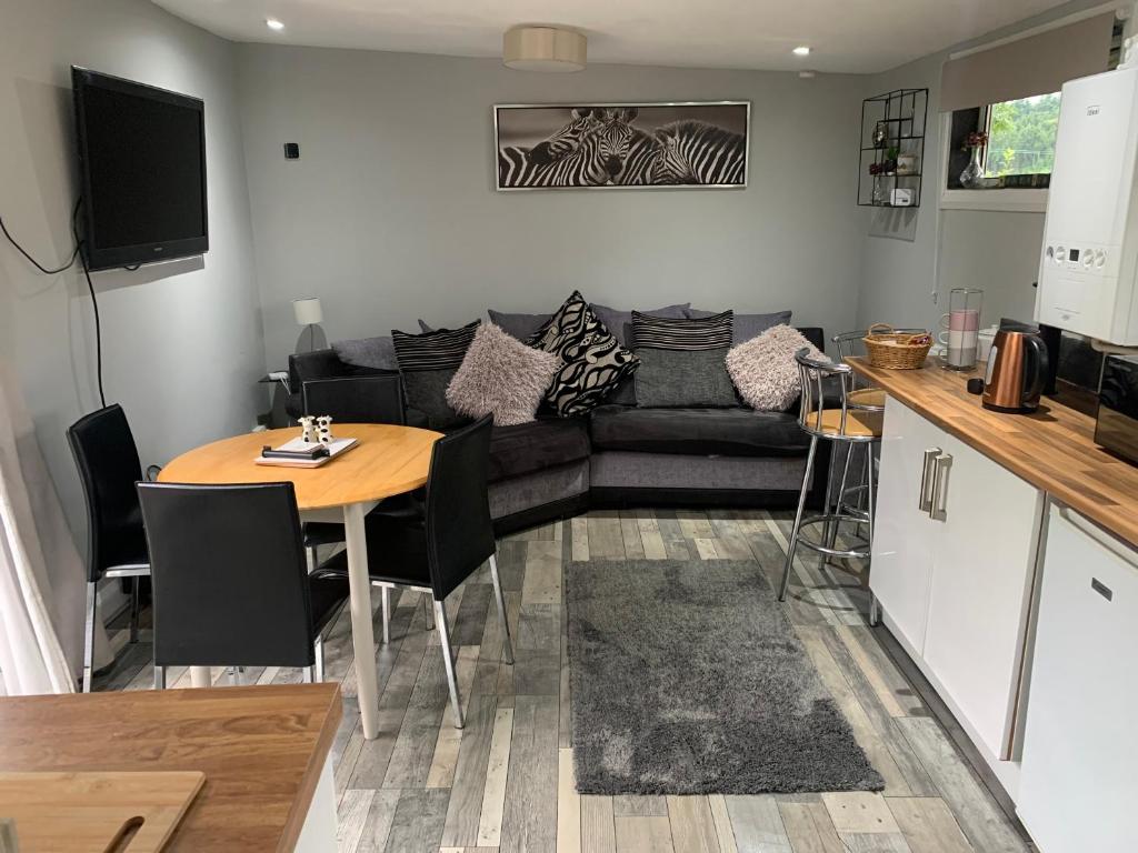 a living room with a couch and a table at 2-Bed Cabin Sleeps 4 -Small Pets Ok -Free Parking in Denbigh