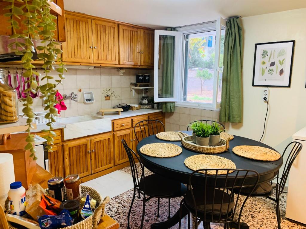 une cuisine avec une table et des chaises dans une cuisine dans l'établissement Airport Cottage House, à Artemi