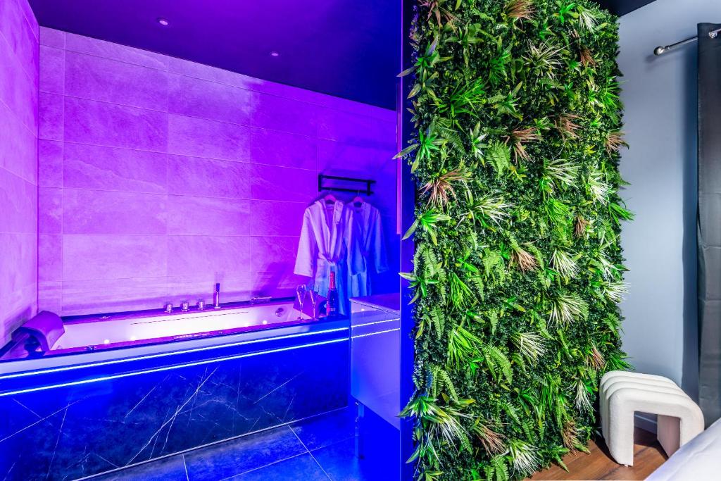 d'un mur de plantes dans une salle de bains pourvue d'un peignoir. dans l'établissement Les Chants de l'Eau avec balnéothérapie, à Thonon-les-Bains