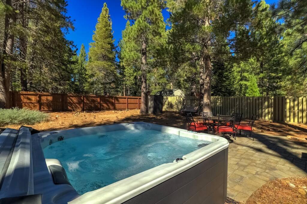 a hot tub in a backyard with a table and chairs at Bear Cub Cabin - Pets - Hot tub - Arcade Game in Mevers