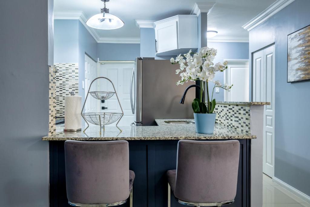 a kitchen with a counter with two chairs and a table at Luxurious Living At Winchester Estate in Camperdown