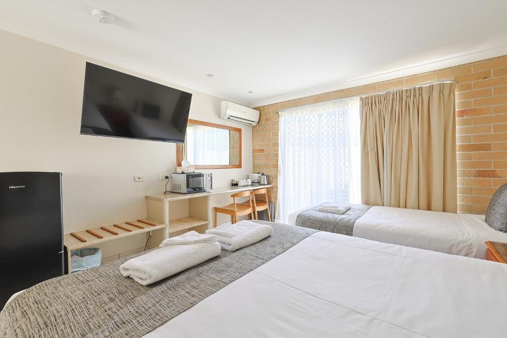 Postel nebo postele na pokoji v ubytování Emerald Central Palms Motel