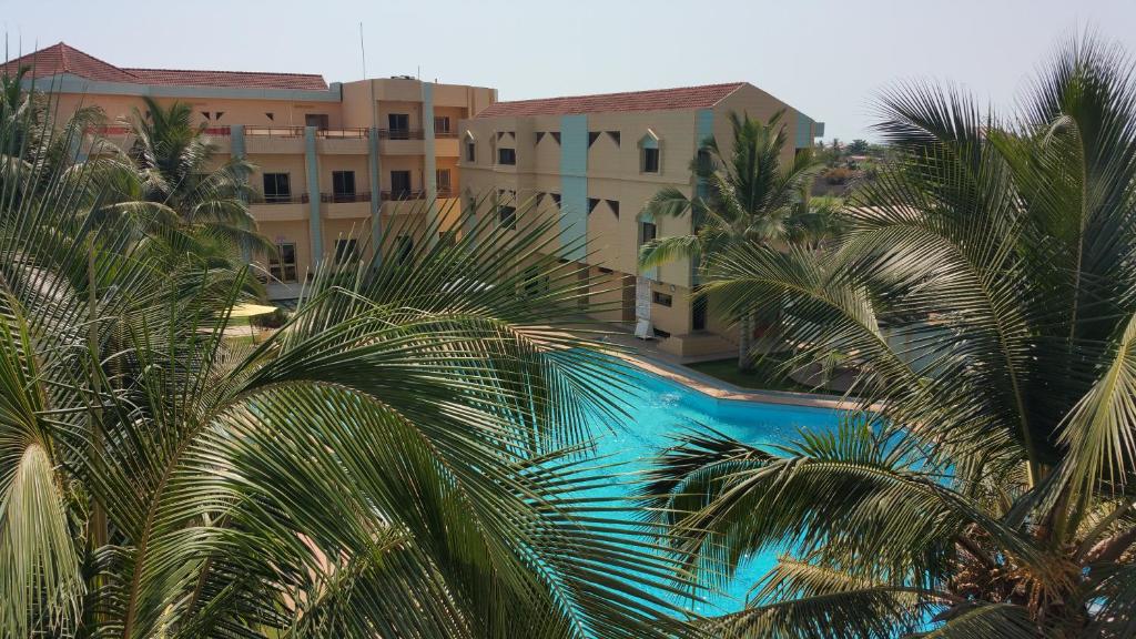 vista sul tetto di una piscina con palme di Hotel Ghis Palace a Baguida