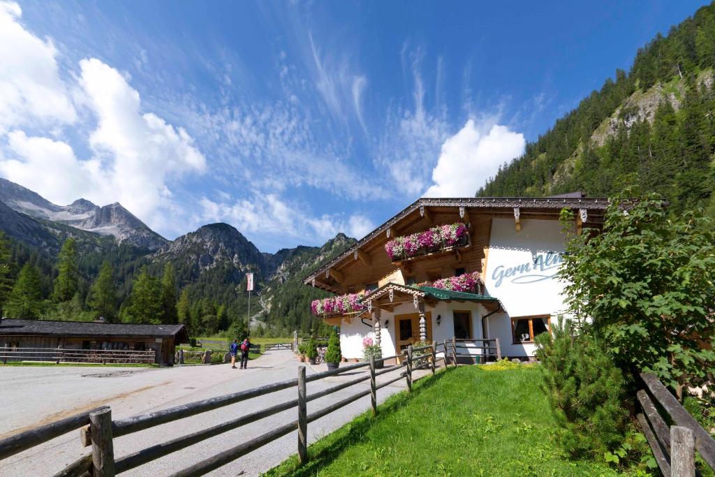 un edificio con flores al lado de una montaña en Alpengasthof Gern Alm, en Pertisau