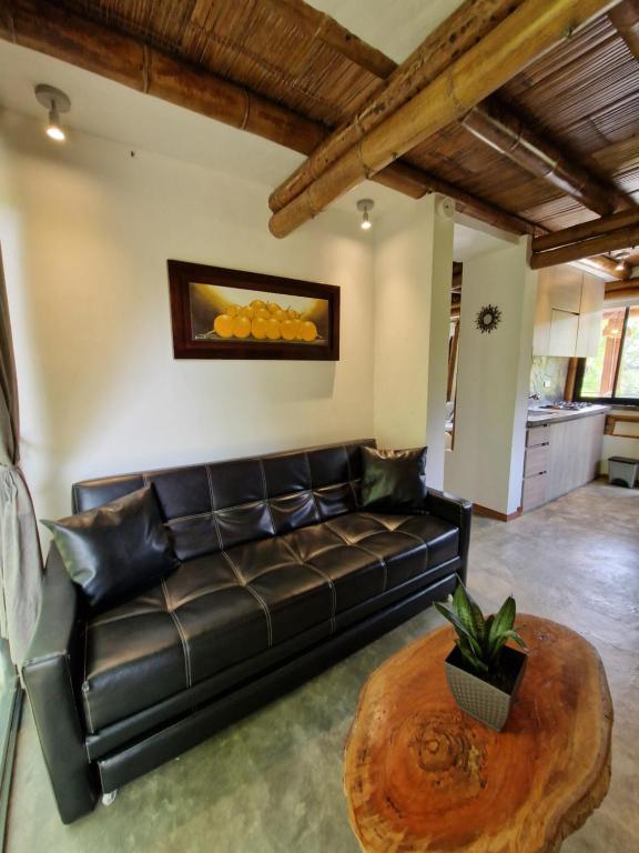 a living room with a leather couch and a table at Bhutan Filandia in Filandia