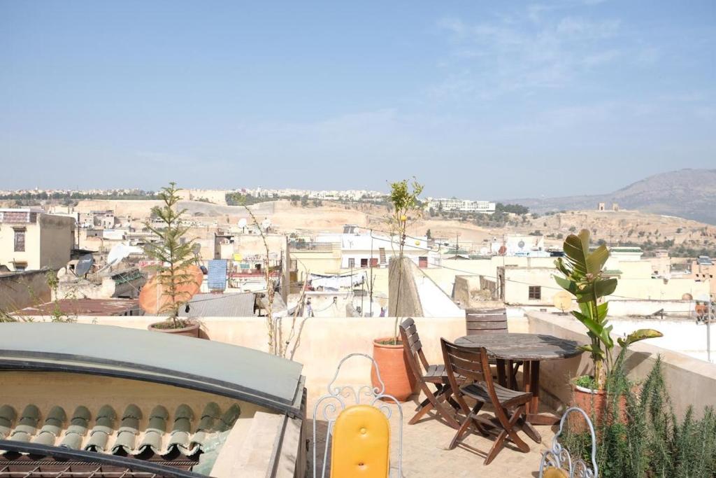 un balcone con tavolo e sedie e vista sulla città di Dar Fes Zahra a Fes