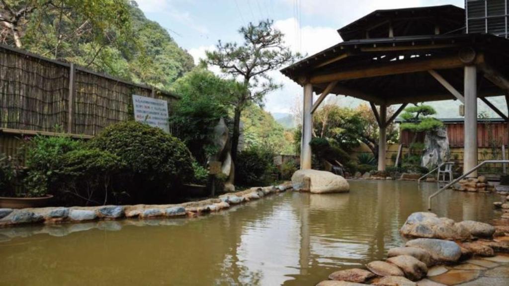 a pool of water with rocks in a garden at Uruoikan in Nagano