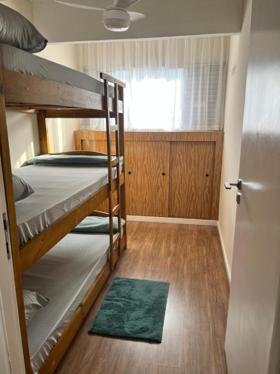 a small room with two bunk beds and a door at 22- APTO NOVO 7 min do Aeroporto de Guarulhos Garagem Coberta in Cumbica