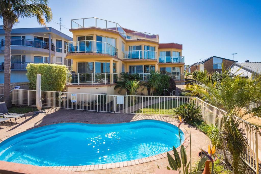 a house with a swimming pool in front of a house at Baywatch 3 in Merimbula