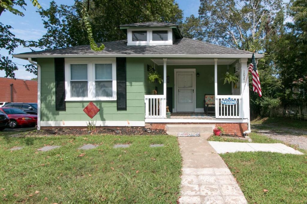 une maison verte dotée d'un drapeau américain devant elle dans l'établissement Hometown Clarksville Cottage, à Clarksville