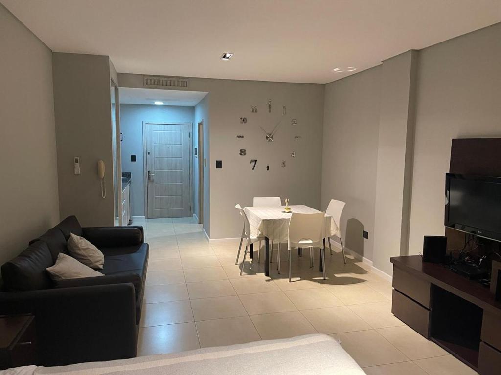 a living room with a couch and a table and a clock at Bahía Loft Nordelta 307 in Benavídez