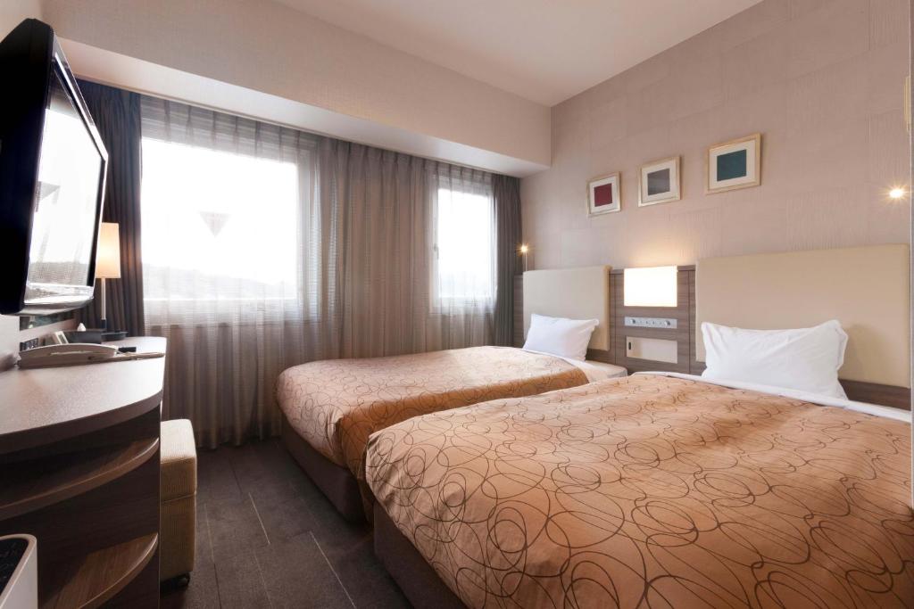 Postel nebo postele na pokoji v ubytování Onomichi Royal Hotel