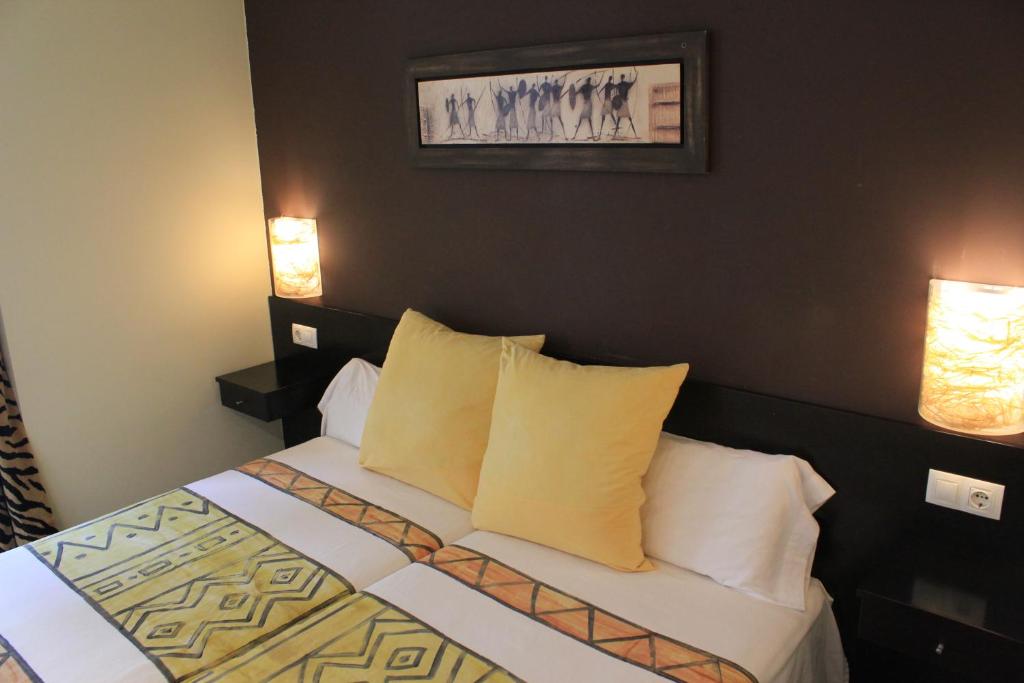 sypialnia z łóżkiem z poduszkami i 2 lampami w obiekcie Pensión Basic Confort w mieście San Sebastián