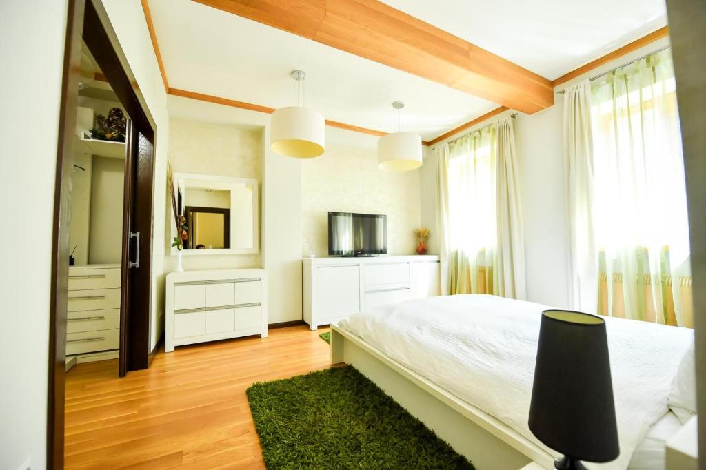 a bedroom with a white bed and a television at Luxury Apartment in Braşov