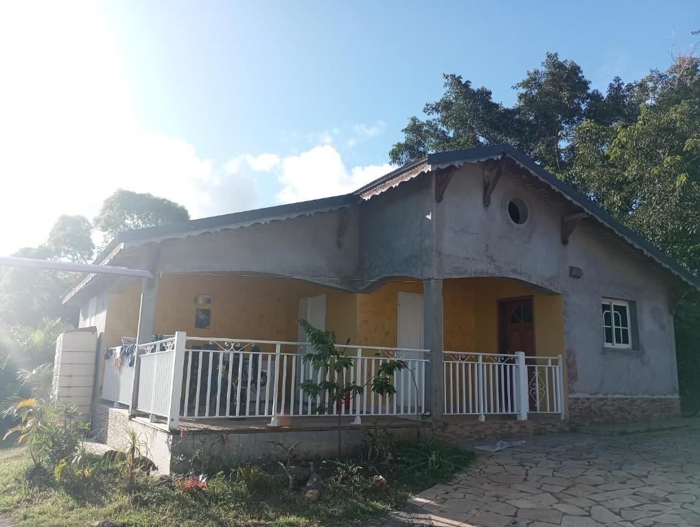 una piccola casa con una recinzione bianca di fronte di Zoranj Delair a Sainte-Anne