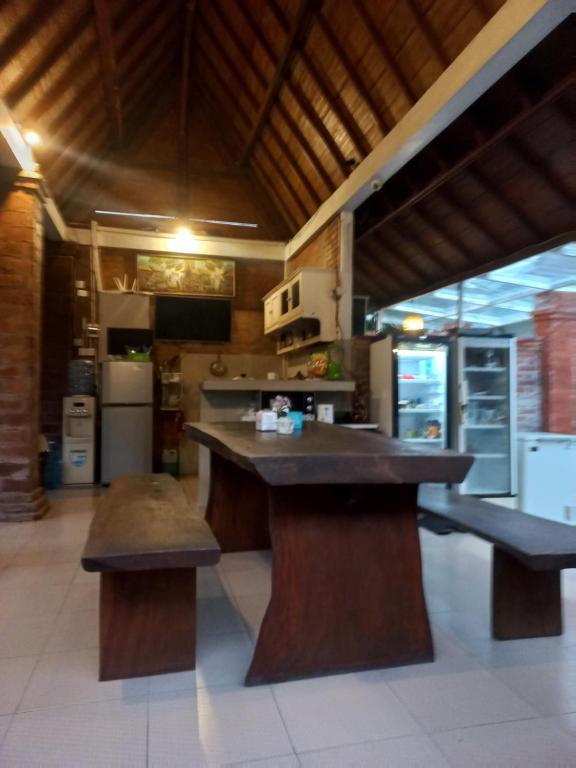 une cuisine avec un grand îlot avec des bancs dans l'établissement ATHAYA GUEST HOUSE canggu, à Kerobokan