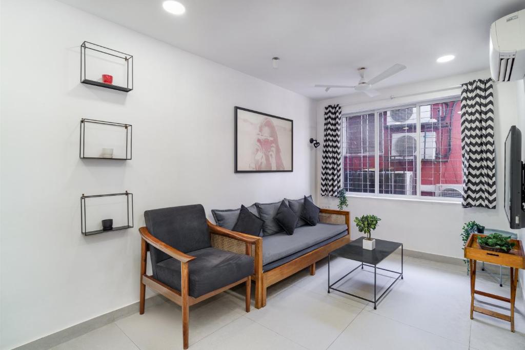 a living room with a couch and a chair at Alcove 1BHK Bandra W by The Bombay Home Company in Mumbai