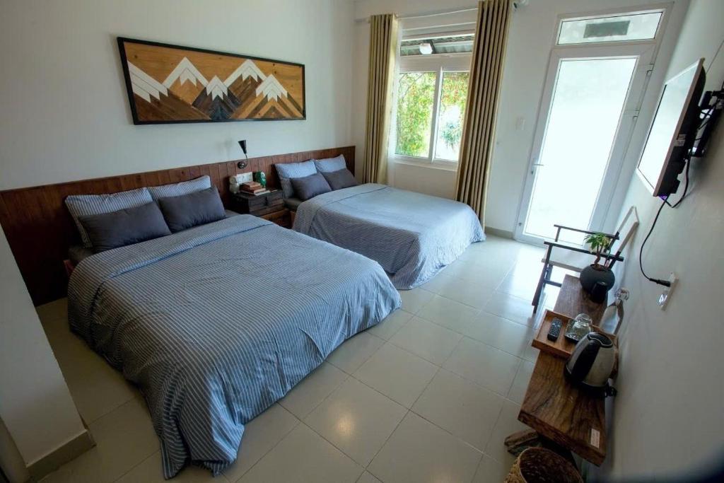 a bedroom with two beds and a window at La nha Homestay in Da Lat