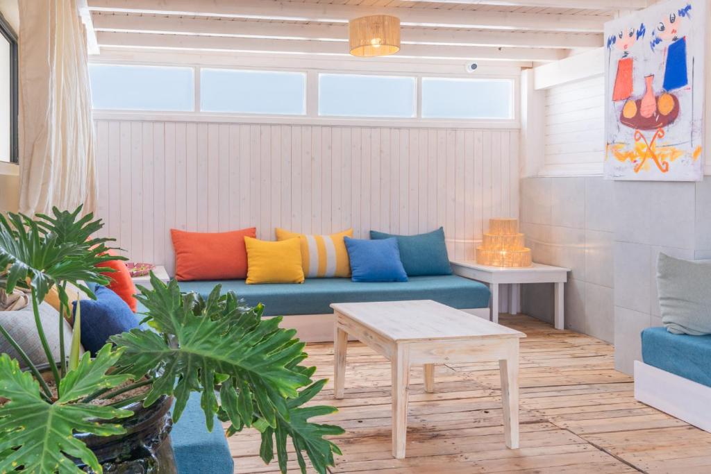 a living room with a blue couch with colorful pillows at Hanah Apartments in Essaouira