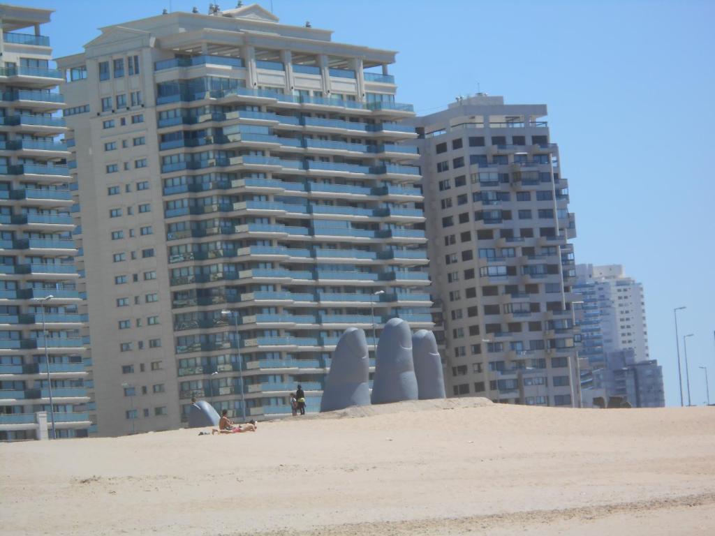 una playa con dos edificios altos en el fondo en Parquemar Center I, en Punta del Este