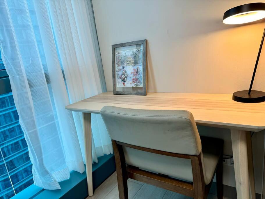 a desk with a chair and a picture on it at BGC 1BR unit linked to Uptown Mall with own parking in Manila