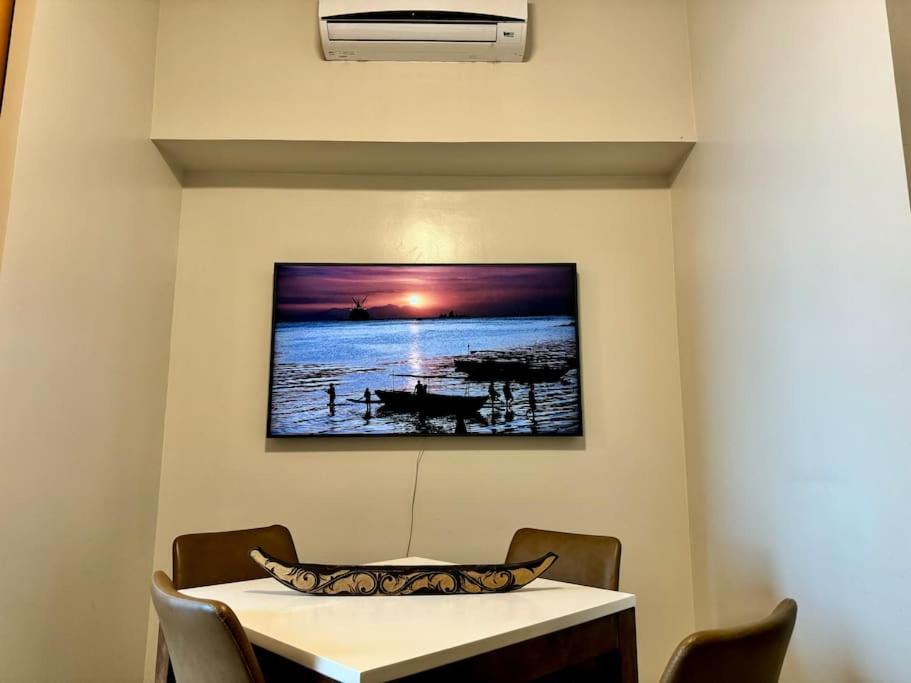 a dining room with a table and a picture on the wall at BGC 1BR unit linked to Uptown Mall with own parking in Manila