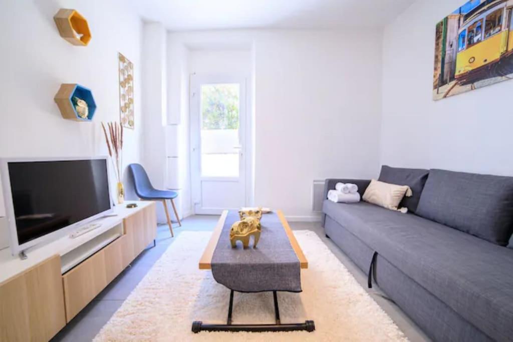 un salon avec un canapé et une télévision dans l'établissement Superb studio with terrace, calm and tranquility, à Cannes