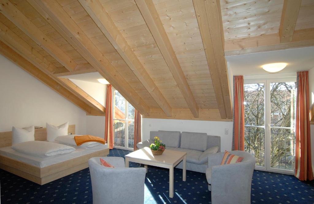 sala de estar con cama, mesa y sillas en Landhaus Sixtmühle, en Taufkirchen