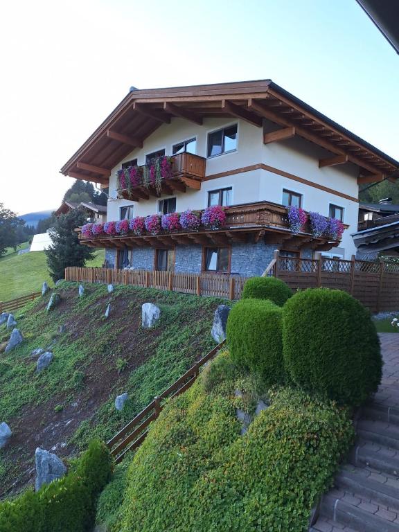a house on a hill with bushes and flowers at Ferienwohnung Julia Kröll in Mittersill