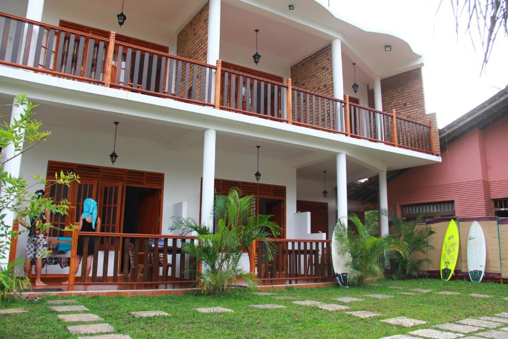 a house with a balcony and a yard at Dilara Resort Mirissa in Mirissa