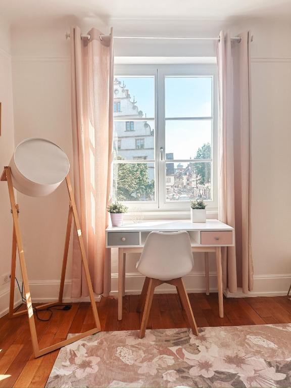 Hotel Pastel au grenier à sel, a desk and a chair in a room with a window at Pastel au grenier à sel in Colmar