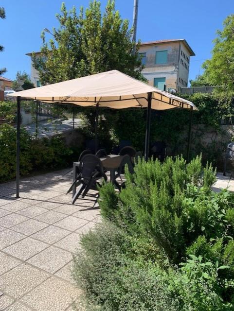 a table and chairs under an umbrella on a patio at Mery's House casa vacanza in Fano