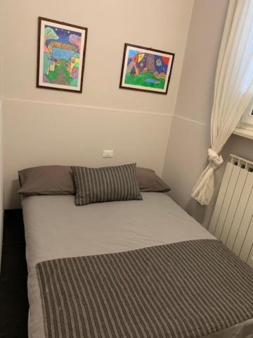 a bed in a bedroom with two pictures on the wall at Mery's House casa vacanza in Fano