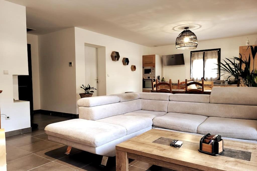 un salon avec un canapé blanc et une table dans l'établissement Charmante villa avec jardin, à Prunete