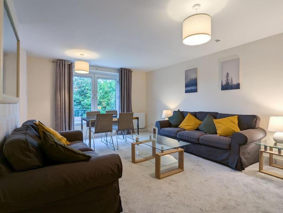 a living room with two couches and a dining room at Parkgate 2 bed, private parking, Rosyth M90 in Rosyth