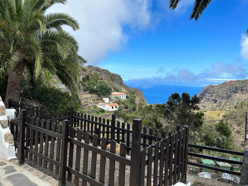 a wooden fence with a view of the ocean at Casa Rural La Vega in Agulo
