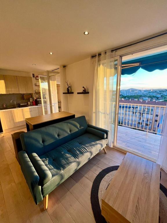 un salon avec un canapé et une grande fenêtre dans l'établissement Appartement spacieux 3 chambre, à Toulon