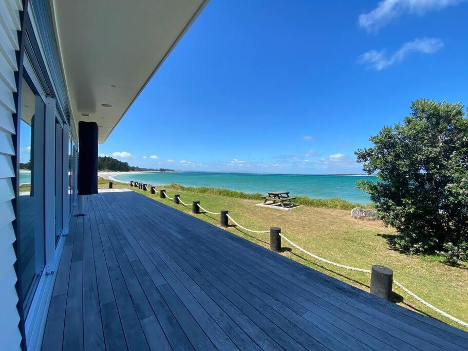 a porch of a house with a view of the ocean at Rangi Beachfront -Luxury Beachfront Bach in Karikari Peninsula