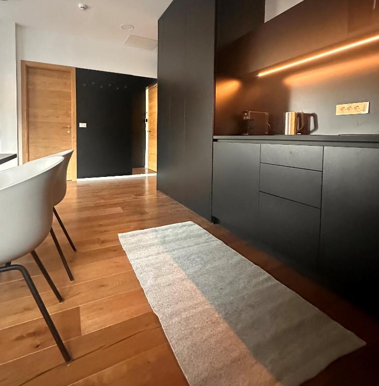 a kitchen with black cabinets and a white rug at Nordic Sun 01 in Kranjska Gora