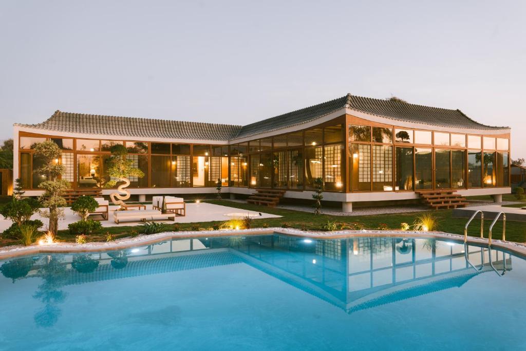 an exterior view of a house with a swimming pool at THE JAPANESE HOUSE by BRIDGE RETREATS in Ras al Khaimah